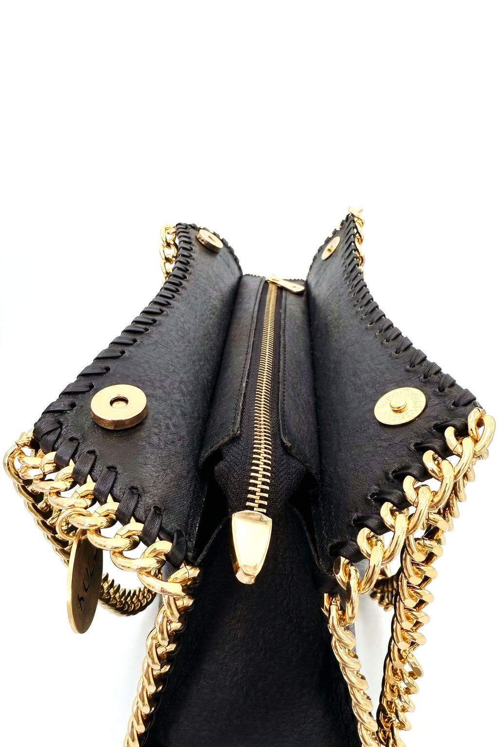 Black leather handbag open view with zipper, magnetic snap closure and gold accents on a white background